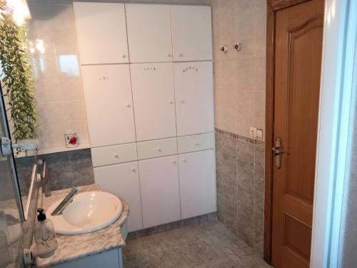 La salle de bains est pourvue d'un lavabo et de placards blancs. dans l'établissement Private room Ribaroja near Valencia, à Riba-roja de Túria