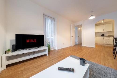 a living room with a flat screen tv on a table at Luxury 2 Bed Apartment Stansted Airport Bishops Stortford in Bishops Stortford
