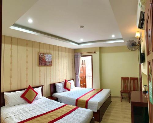 a hotel room with two beds and a window at Hoa Sua Hotel in Vung Tau