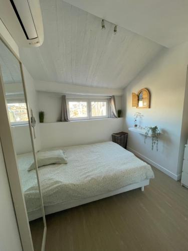 a bedroom with a bed and two windows at Magnifique Duplex Vieil Antibes in Antibes