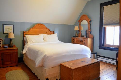 a bedroom with a large bed with a wooden headboard at Magnetic Hill Winery in Moncton