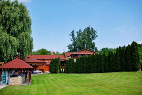een huis met een grote tuin met een groen gazon bij A SZELLŐ 