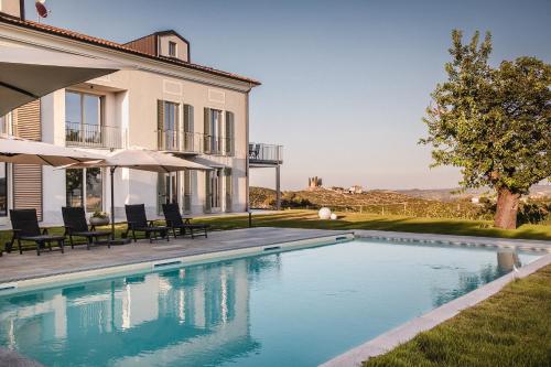 a swimming pool in front of a house at Villa Vinory Bricco di Nizza in Nizza Monferrato