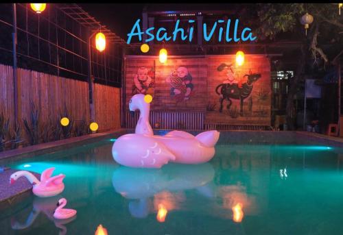 a swimming pool with pink flamingos in the water at Asahi Villa Tam Coc in Ninh Binh