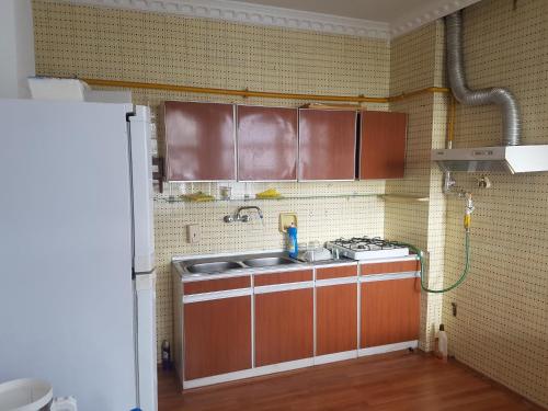 Il comprend une cuisine équipée d'un évier et d'une cuisinière. dans l'établissement Просторная квартира 2 plus 1 с панорамным видом на море, à Darıca