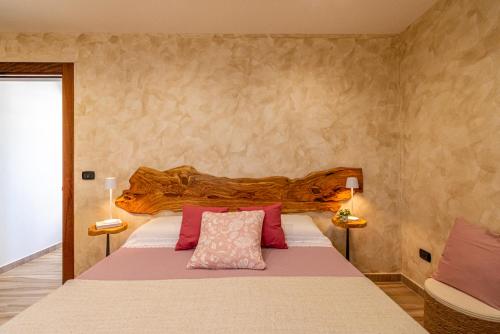 Un dormitorio con una cama grande con almohadas rosas. en La terrazza di Zoe - Castromediano ( Lecce), en Cavallino di Lecce