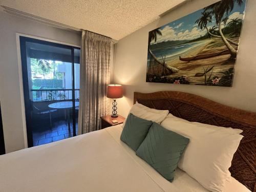 a bedroom with a bed and a view of a balcony at Kaanapali Royal B201 in Lahaina