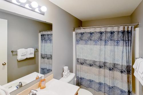a bathroom with a shower curtain and a toilet at Park Pointe Mutual in Chelan