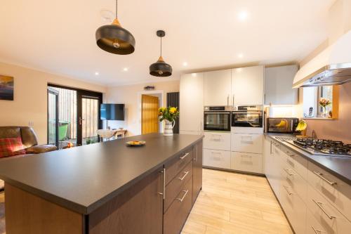 a large kitchen with a large black counter top at Silverbridge Lodge in Garve