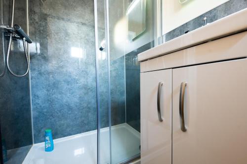 een badkamer met een douche en een glazen deur bij Silverbridge Lodge in Garve