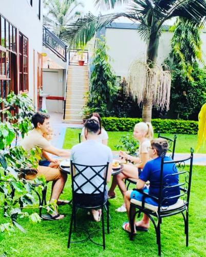 a group of people sitting around a table in the grass at Green Mountain Hotel in Arusha