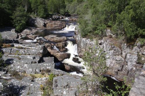 an aerial view of a waterfall on a rocky mountain at Silverbridge Lodge in Garve