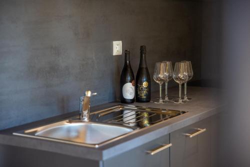 a kitchen with a sink and two wine bottles and glasses at Wine Camp Hažić in Grabrovnik