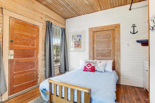 a bedroom with a bed and a wooden door at Lucky Number #13 in Tybee Island