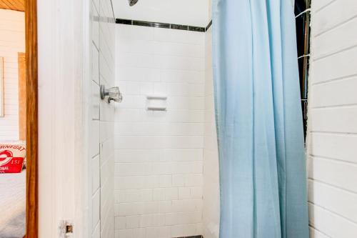 a bathroom with a shower with a blue shower curtain at Lucky Number #13 in Tybee Island