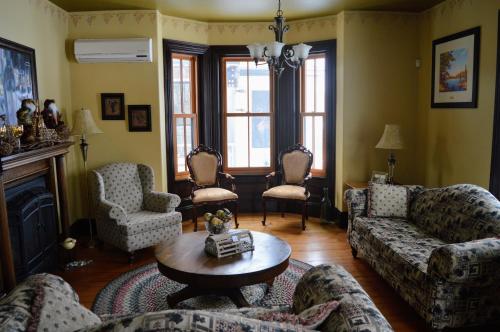 un soggiorno con divano, sedie e tavolo di Magnetic Hill Winery a Moncton