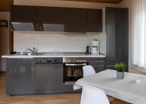 a kitchen with stainless steel appliances and a table at Ferienhaus Am Reilsbach in Cochem