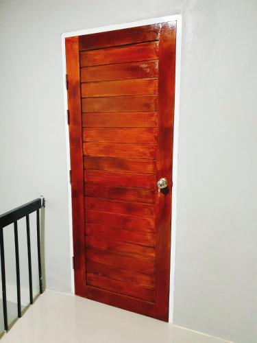 a wooden door in the corner of a room at Phakdee Place in Chanthaburi