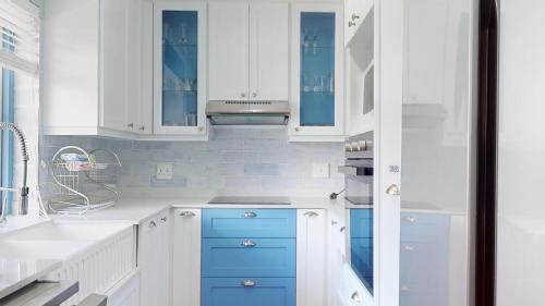 a kitchen with white cabinets and blue drawers at 36 Montego Bay Caribbean Estate by Top Destinations Rentals in Port Edward