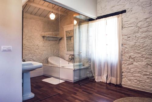 a bathroom with a shower and a tub and a sink at Houmi A Ponte in Boimorto