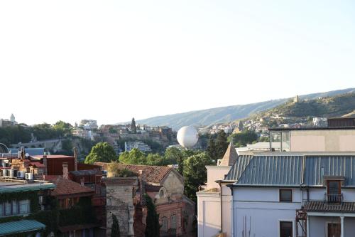 a city with a hot air balloon in the distance at Mukhrantubani Boutique Hotel in Tbilisi City