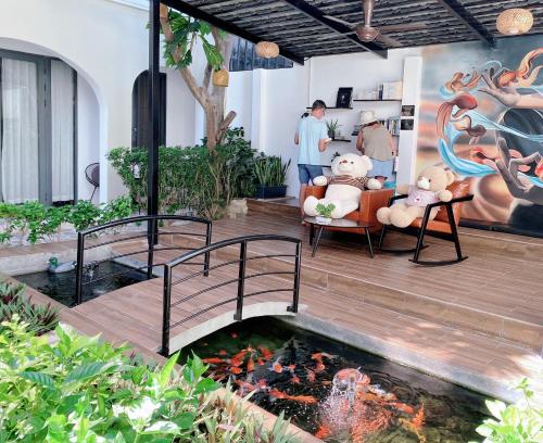 two teddy bears sitting in a chair next to a pond at KA VILLA - AN BANG BEACH, Free pick up 3 nights in Hoi An