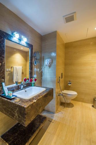 a bathroom with a large marble sink and a toilet at Erfad Hotel - Riyadh in Riyadh