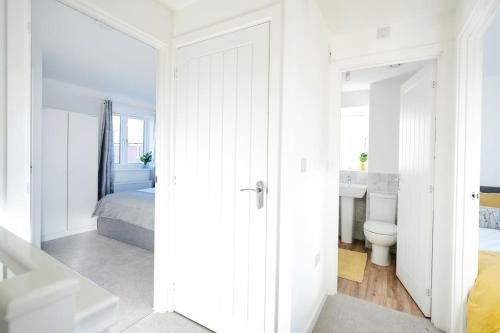 a white bedroom with a bed and a toilet at Fortified Three Bedroom Home Bristol 