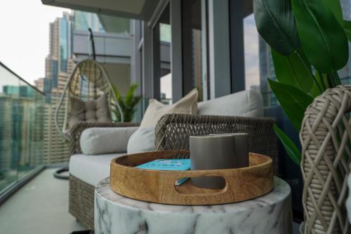 Majestay - Luxury Living في دبي: غرفة معيشة مع طاولة مع كوب قهوة عليها