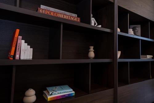 a book shelf with books and vases on it at Majestay - Luxury Living in Dubai