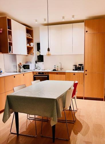 une cuisine avec une table et des chaises dans une pièce dans l'établissement Marais - Appartement sur les toits, à Paris