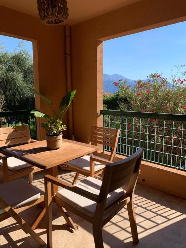 a porch with a wooden table and chairs and a window at Raffiné appartement in Saint-Jean-Cap-Ferrat