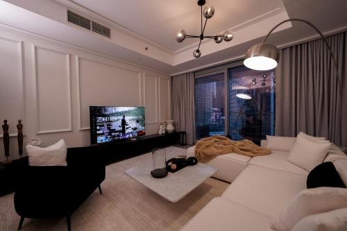 a living room with a white couch and a television at Majestay - Luxury Living in Dubai