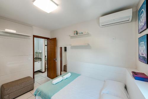 een witte slaapkamer met een bed en een raam bij Studio c Localização Exclusiva em Jardim da Penha in Vitória