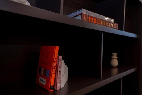 a book shelf with two books and a vase on it at Majestay - Luxury Living in Dubai