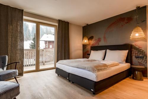 a bedroom with a large bed and a balcony at CHILL HOUSE in Schladming