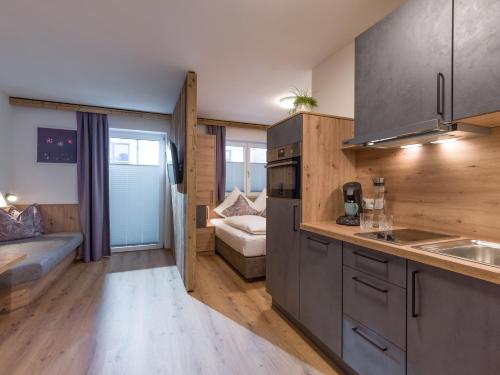 a kitchen with a sink and a couch in a room at Alps Holaus in Aschau