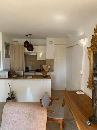 een woonkamer met een tafel en een keuken bij Raffiné appartement in Saint-Jean-Cap-Ferrat