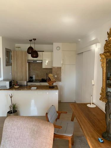 a living room with a table and a kitchen at Raffiné appartement in Saint-Jean-Cap-Ferrat