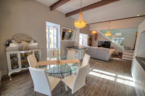 a dining room with a glass table and white chairs at Spectacular spacious house with sun terrace ILJU1-1 in Sliema