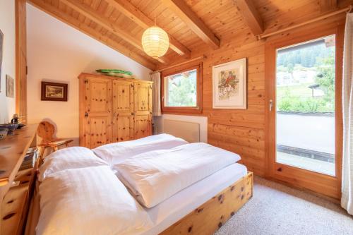 um quarto com uma cama numa casa de madeira em Casa Pleun em Flims
