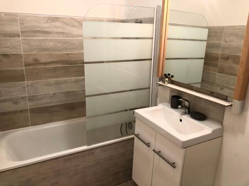 une salle de bain avec un lavabo et une baignoire dans l'établissement Studio Villennes sur Seine près de la gare, à Villennes-sur-Seine