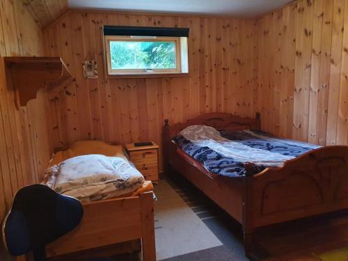 Hitra的住宿－Vingvågen hygge og ro，一间卧室设有两张床和窗户。