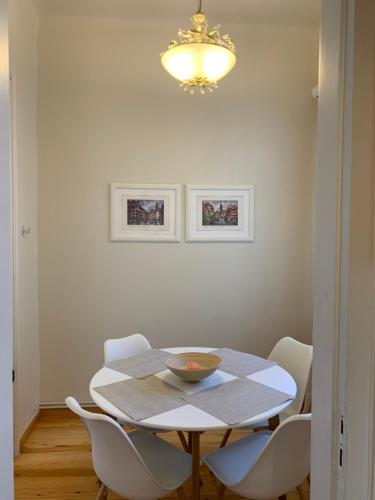 a dining room table with white chairs and a chandelier at Anavros beach house in Volos