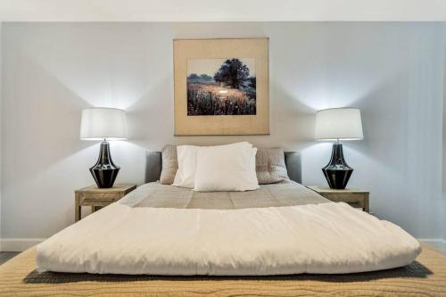 una camera da letto con un grande letto bianco con due lampade di Great View House Hot Tub Fire Pit a Twentynine Palms