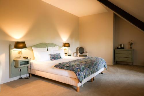 - une chambre avec un lit, une commode et des lampes dans l'établissement Château de Fontanges, à Onet le Château