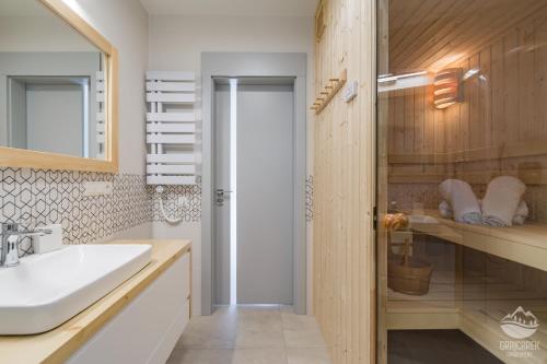 uma casa de banho com um lavatório e um espelho em Apartament Grajcarek em Jaworki