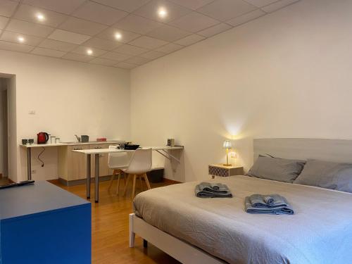 a bedroom with a bed and a table and a desk at LHE Les Trois Merveilles in Cesena