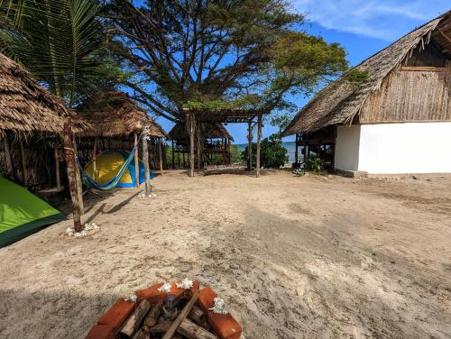 a playground in front of a building with a tree at Mawe Mawili in Tanga