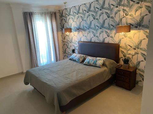 a bedroom with a bed with a floral wallpaper at Appartment Anjou in Casablanca